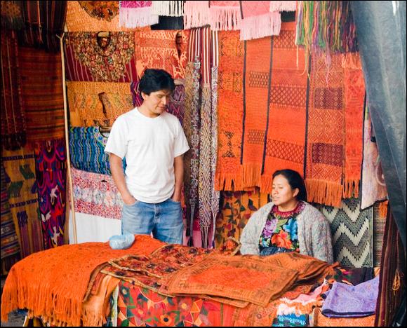 A market stall on Sunday, fabrics and rugs are the main produce to interest tourists