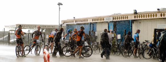 At the finish line, people take cover from a sudden downpour