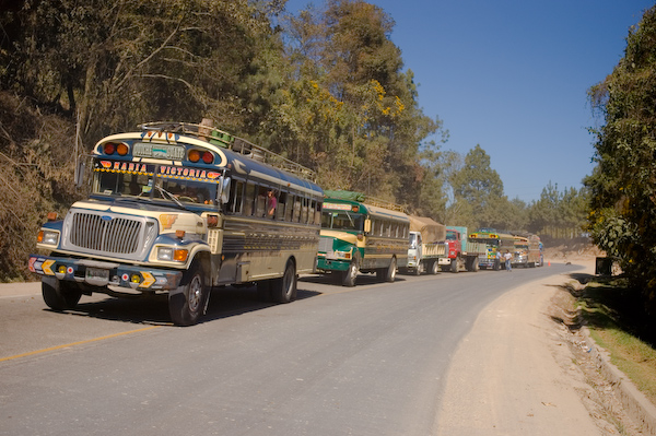 From the Guatemala gallery, vividly repainted US school buses queue on the road to Guatemala City 