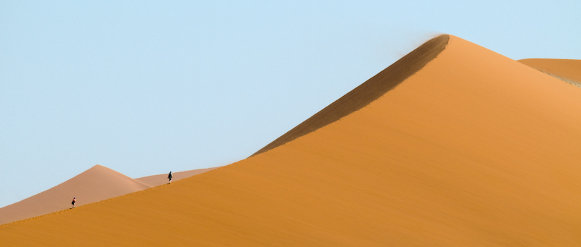 Sossusvlei Dune, Namibia. You can see the strong wind from the dust cloud on the top of the dune.
